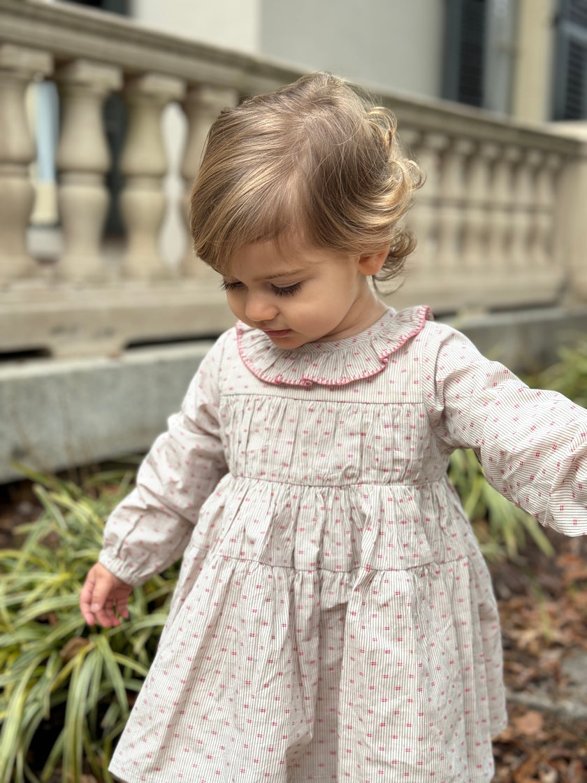This long-sleeve empire line dress with pleated bodice and neck frill has a classic silhouette. In our beautiful red dot ticking fabric and finished with red blanket stitch on the frill.