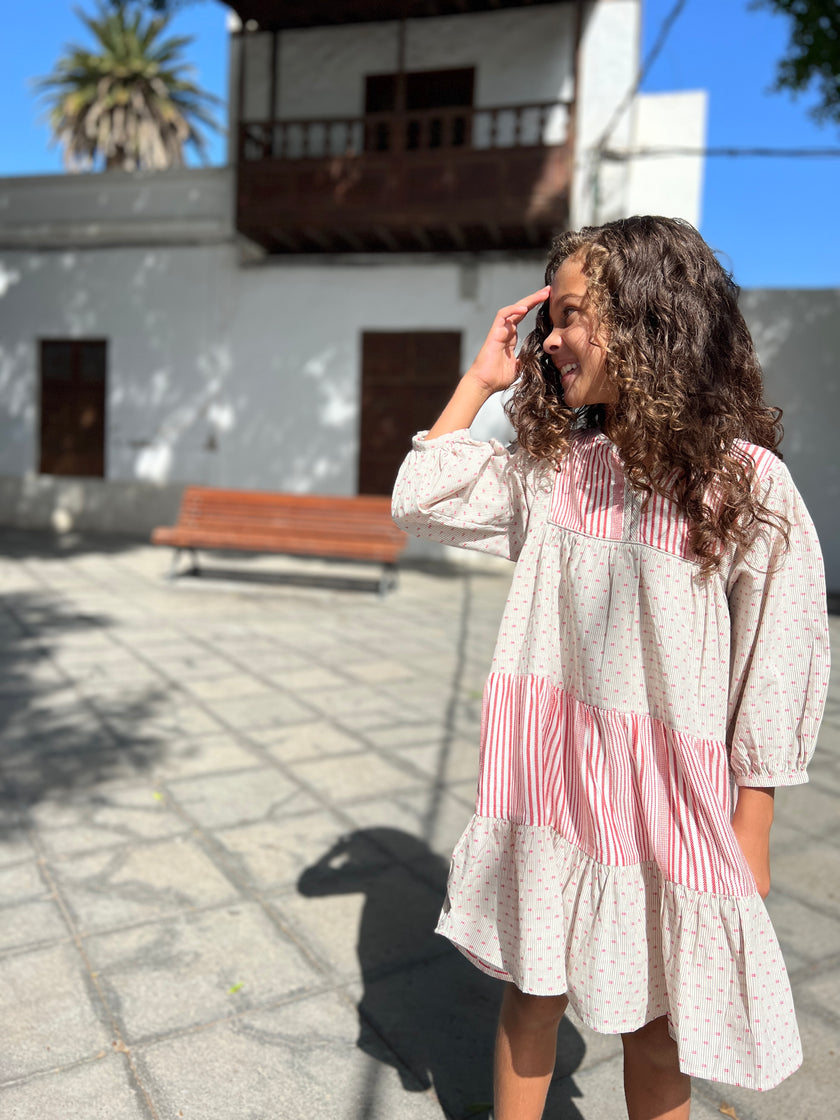 Knee length tiered dress in contrasting ivory/red stripe and grey ticking fabric. With button fastenings on the placket.